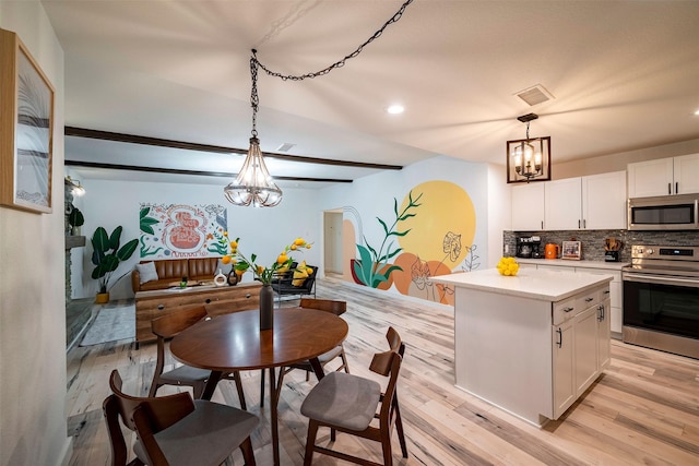 5918 Lattimer Dr, Houston, TX 77035 - kitchen featuring appliances with stainless steel finishes, a chandelier, light countertops, white cabinetry, and backsplash