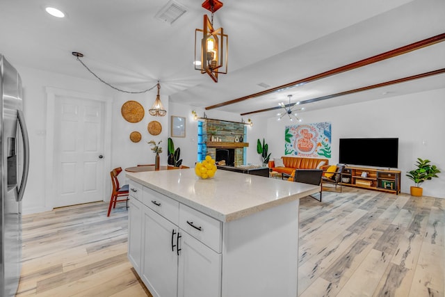 5918 Lattimer Dr, Houston, TX 77035 - kitchen with stainless steel fridge with ice dispenser, light wood-style flooring, a stone fireplace, open floor plan, and recessed lighting