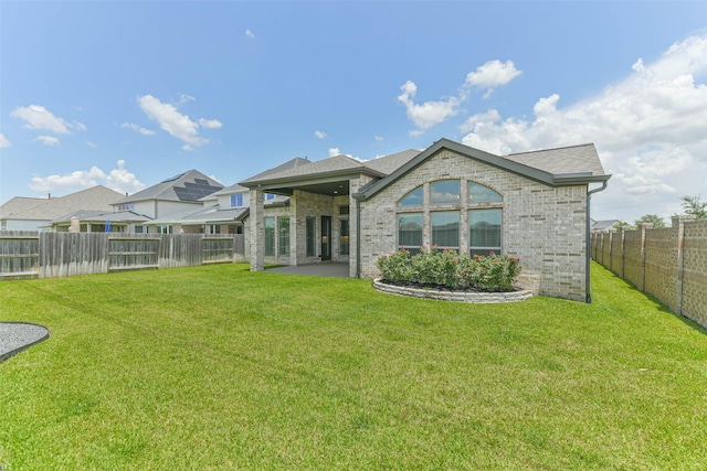 20519 Grazing Foal Ln, Tomball, TX 77377 - rear view of house featuring a fenced backyard, brick siding, and a patio area