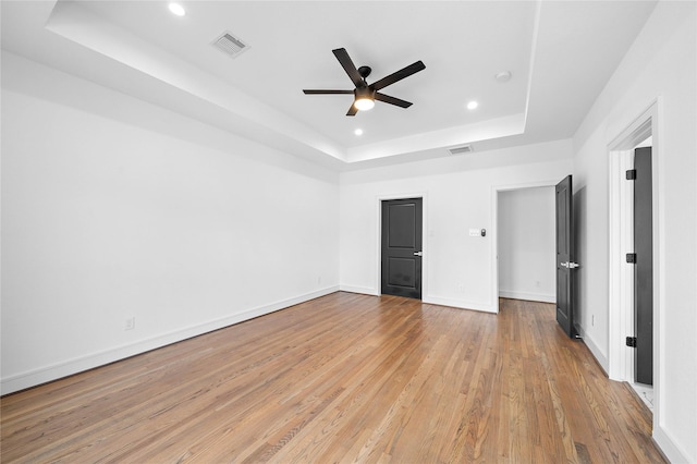 1011 E 28th St, Houston, TX 77009 - unfurnished bedroom featuring a raised ceiling, recessed lighting, light wood-type flooring, and a ceiling fan