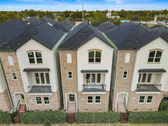1011 E 28th St, Houston, TX 77009 - french country style house featuring a balcony, brick siding, and stucco siding
