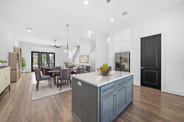 1011 E 28th St, Houston, TX 77009 - kitchen featuring stainless steel refrigerator with ice dispenser, wood finished floors, white cabinets, a center island, and open floor plan