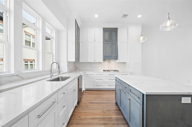1011 E 28th St, Houston, TX 77009 - kitchen with healthy amount of natural light, white cabinets, recessed lighting, light wood-style flooring, and ornamental molding