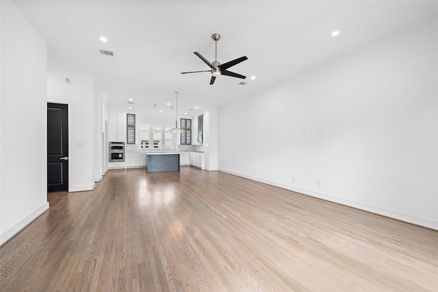 1011 E 28th St, Houston, TX 77009 - unfurnished living room featuring ceiling fan, wood finished floors, and recessed lighting