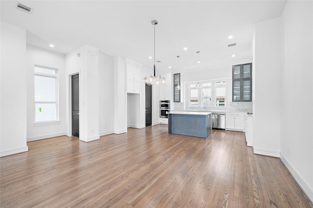 1011 E 28th St, Houston, TX 77009 - unfurnished living room featuring healthy amount of natural light, a chandelier, light wood-type flooring, and recessed lighting