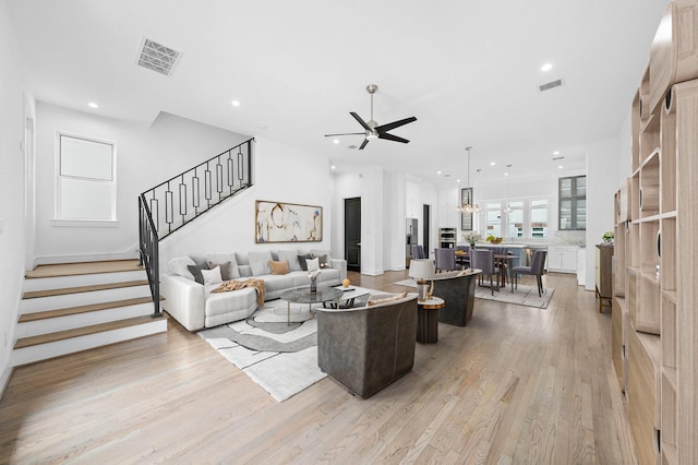 1011 E 28th St, Houston, TX 77009 - living area featuring ceiling fan, stairs, light wood finished floors, recessed lighting, and a chandelier
