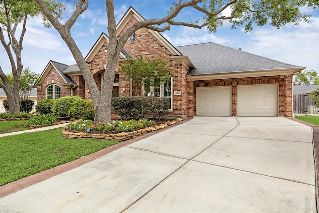 12210 Pebble Mdws, Houston, TX 77041 - traditional home with brick siding, an attached garage, concrete driveway, a front lawn, and a shingled roof