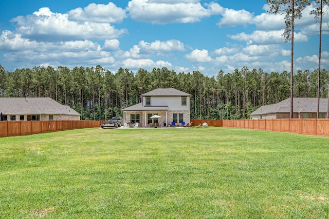 1563 Rd 66114, Dayton, TX 77535 - fenced backyard featuring a forest view and a patio
