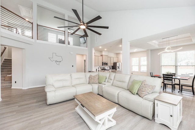 1563 Rd 66114, Dayton, TX 77535 - living room featuring a ceiling fan, stairs, light wood-style flooring, and high vaulted ceiling