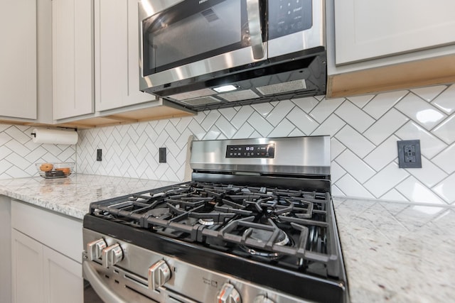 1563 Rd 66114, Dayton, TX 77535 - kitchen with appliances with stainless steel finishes, backsplash, and light stone countertops