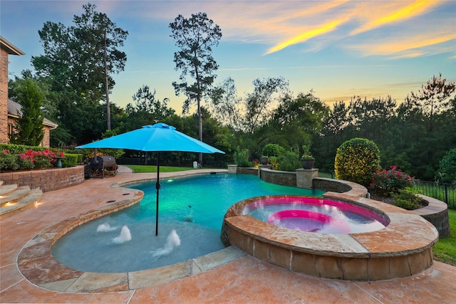 5523 Harvest Oak Landing Dr, Spring, TX 77386 - pool at dusk featuring grilling area, a patio, a pool with connected hot tub, and view of scattered trees