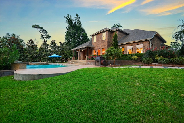 5523 Harvest Oak Landing Dr, Spring, TX 77386 - rear view of house with brick siding, an outdoor pool, a lawn, and roof with shingles