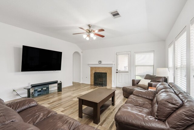 20930 Morgan Knoll Ln, Katy, TX 77449 - living area with light wood-style floors, vaulted ceiling, arched walkways, ceiling fan, and a tiled fireplace