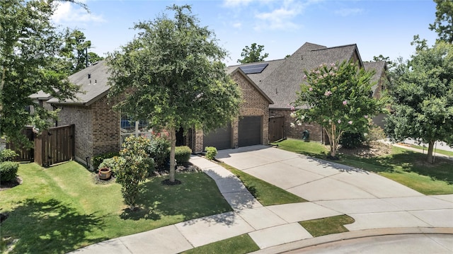16711 Ramsay Cascades Dr, Humble, TX 77346 - view of front of home with brick siding, concrete driveway, a front yard, and roof mounted solar panels