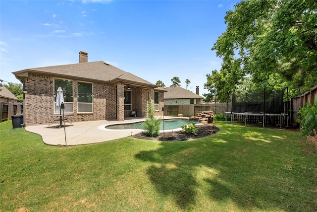 16711 Ramsay Cascades Dr, Humble, TX 77346 - rear view of property featuring brick siding, a trampoline, a fenced backyard, and a chimney
