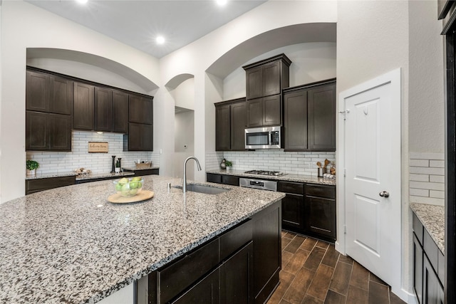 16711 Ramsay Cascades Dr, Humble, TX 77346 - kitchen featuring stainless steel appliances, tasteful backsplash, light stone countertops, dark wood-style flooring, and recessed lighting