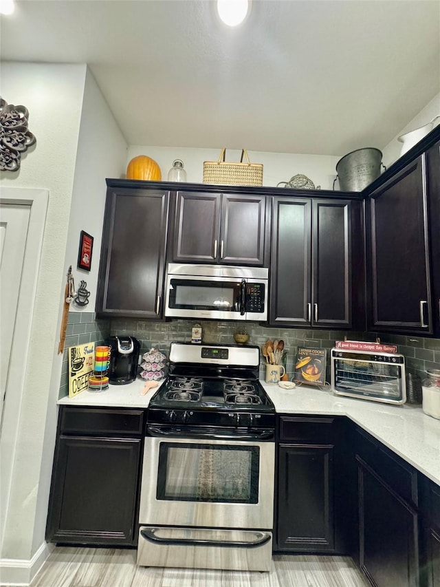 147 Castlegate Ln, Jersey Village, TX 77065 - kitchen with stainless steel appliances, light countertops, decorative backsplash, and dark cabinetry