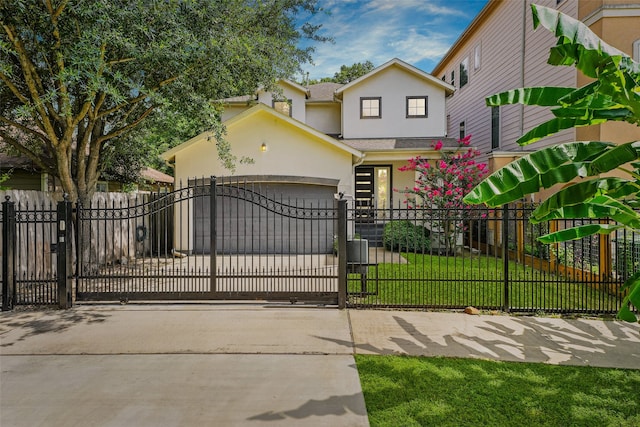 5204 Maxie St, Houston, TX 77007 - view of front of house with stucco siding, a gate, a fenced front yard, an attached garage, and driveway