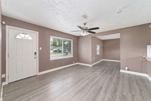 9333 Fairland Dr, Houston, TX 77051 - foyer featuring healthy amount of natural light, a textured ceiling, a ceiling fan, and light wood-style floors