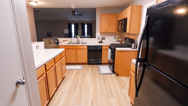 2926 Umiak Dr, Houston, TX 77045 - kitchen with black appliances, light countertops, light wood finished floors, and a peninsula
