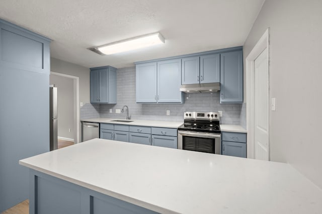 14902 Forest Lodge Dr, Houston, TX 77070 - kitchen with stainless steel appliances, under cabinet range hood, tasteful backsplash, light countertops, and a textured ceiling