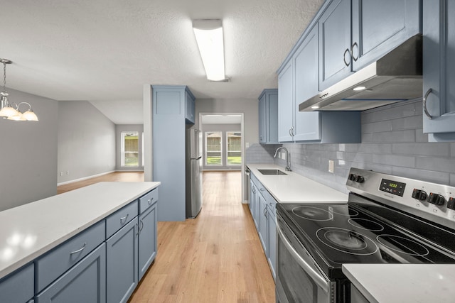 14902 Forest Lodge Dr, Houston, TX 77070 - kitchen featuring stainless steel appliances, under cabinet range hood, blue cabinets, light countertops, and a textured ceiling