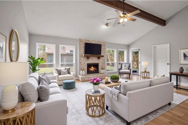 14902 Forest Lodge Dr, Houston, TX 77070 - living area featuring beam ceiling, wood finished floors, healthy amount of natural light, a stone fireplace, and high vaulted ceiling
