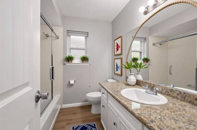14902 Forest Lodge Dr, Houston, TX 77070 - bathroom featuring wood finished floors, healthy amount of natural light, vanity, and combined bath / shower with glass door