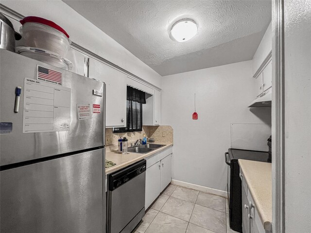 3412 Lantern Ln, Baytown, TX 77521 - kitchen with stainless steel appliances, light countertops, white cabinetry, a textured ceiling, and under cabinet range hood
