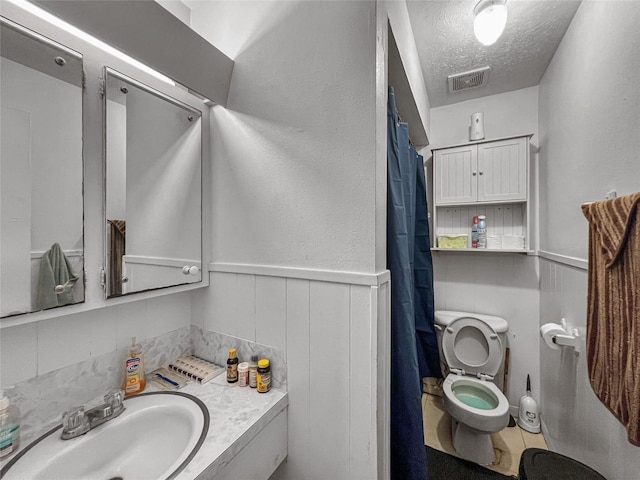 3412 Lantern Ln, Baytown, TX 77521 - full bath with a textured ceiling, vanity, a wainscoted wall, decorative backsplash, and curtained shower