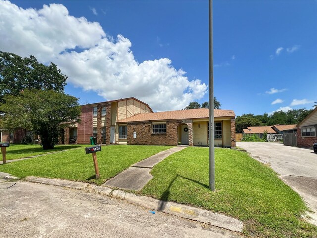 3412 Lantern Ln, Baytown, TX 77521 - view of front of house featuring a front lawn, brick siding, and driveway