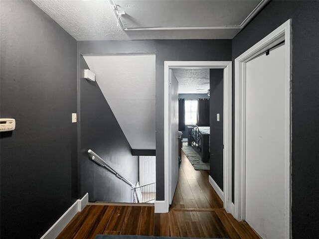 3412 Lantern Ln, Baytown, TX 77521 - corridor with wood finished floors, an upstairs landing, and a textured ceiling