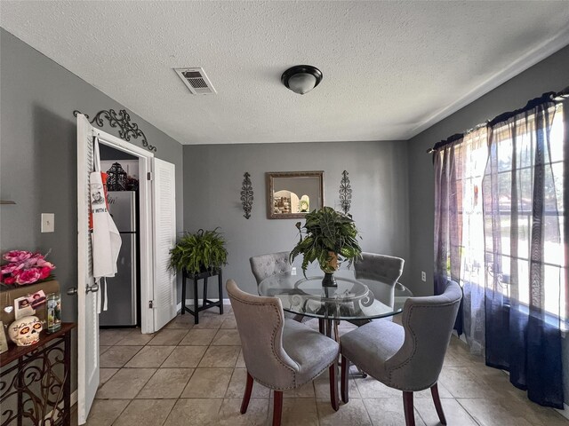 3412 Lantern Ln, Baytown, TX 77521 - dining space featuring light tile patterned flooring and a textured ceiling