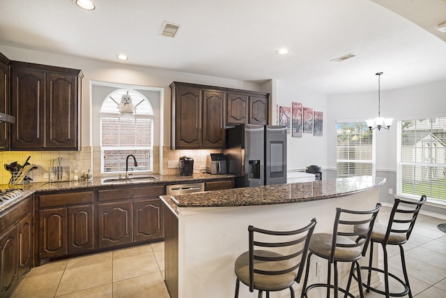 20692 Oakhurst Meadows Dr, Porter, TX 77365 - kitchen featuring stainless steel appliances, a kitchen island, light tile patterned floors, a breakfast bar area, and recessed lighting
