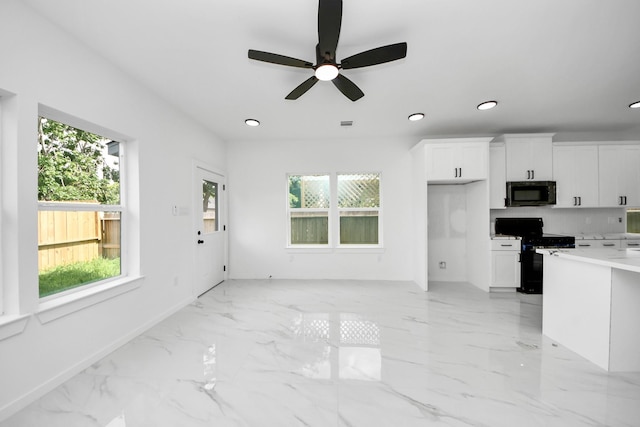 8023 Brandon St, Houston, TX 77051 - kitchen with black appliances, light marble finish flooring, recessed lighting, white cabinetry, and healthy amount of natural light