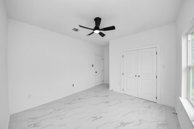 8023 Brandon St, Houston, TX 77051 - unfurnished bedroom featuring light marble finish flooring, multiple windows, a closet, and a ceiling fan