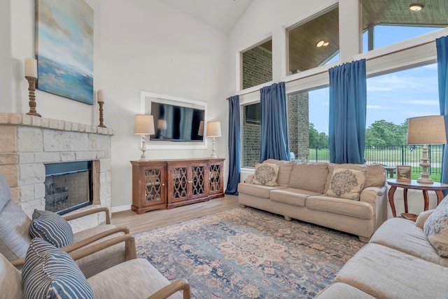 97 La Costa Dr, Montgomery, TX 77356 - living room featuring wood finished floors, plenty of natural light, high vaulted ceiling, and a stone fireplace