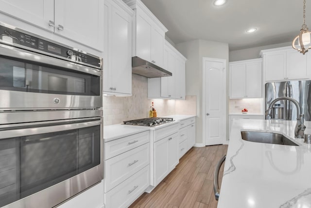 97 La Costa Dr, Montgomery, TX 77356 - kitchen featuring appliances with stainless steel finishes, under cabinet range hood, white cabinets, backsplash, and recessed lighting