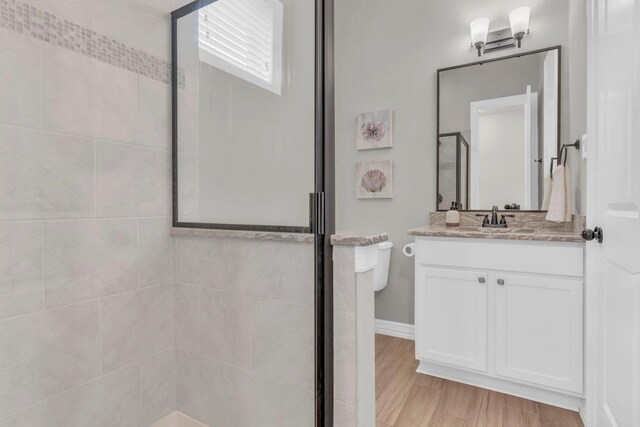 97 La Costa Dr, Montgomery, TX 77356 - full bathroom featuring a shower stall, vanity, and wood finished floors