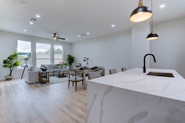 1306 Evelyn St, Houston, TX 77009 - kitchen featuring recessed lighting, hanging light fixtures, light stone counters, light wood-style flooring, and a ceiling fan