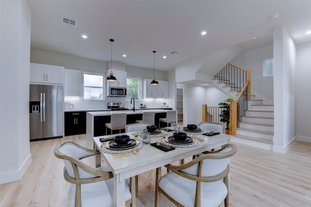1306 Evelyn St, Houston, TX 77009 - dining space with stairway, light wood-style flooring, and recessed lighting