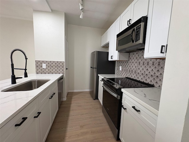 9850 Pagewood Ln Unit 909, Houston, TX 77042 - kitchen featuring stainless steel appliances, backsplash, white cabinets, and light stone counters