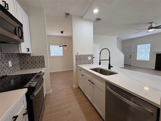 9850 Pagewood Ln Unit 909, Houston, TX 77042 - kitchen featuring appliances with stainless steel finishes, white cabinets, light stone counters, decorative backsplash, and recessed lighting