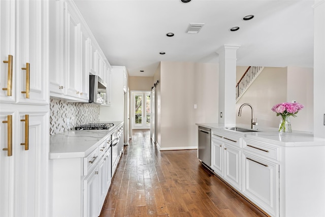 7127 Vermejo Park Ln, Humble, TX 77346 - kitchen featuring stainless steel appliances, dark wood finished floors, backsplash, white cabinets, and recessed lighting