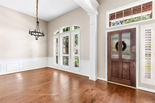 7127 Vermejo Park Ln, Humble, TX 77346 - entryway featuring wainscoting, wood finished floors, decorative columns, and a chandelier