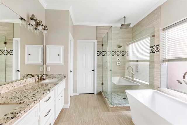 7127 Vermejo Park Ln, Humble, TX 77346 - full bath with ornamental molding, a freestanding tub, a stall shower, double vanity, and wood finished floors