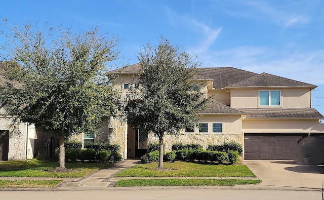 2 Chalice Trl, Sugar Land, TX 77498 - view of front of home with stucco siding, stone siding, an attached garage, and driveway