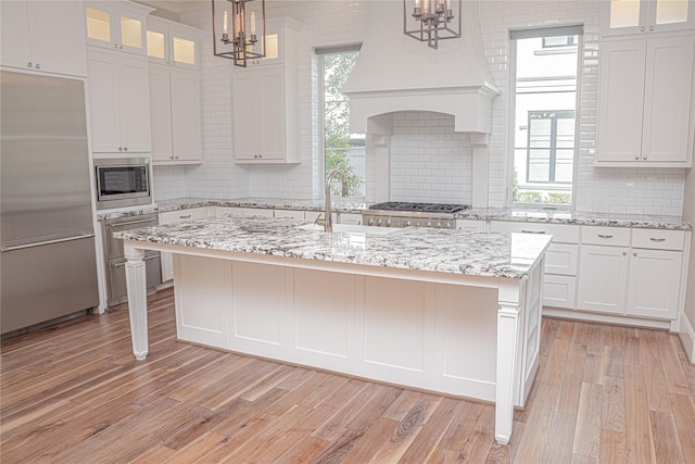 1530 Cunningham Parc Ln, Houston, TX 77055 - kitchen featuring built in appliances, a chandelier, tasteful backsplash, and light wood-style flooring