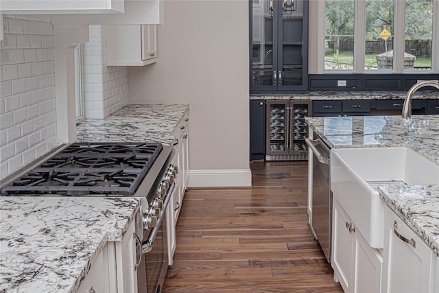 1530 Cunningham Parc Ln, Houston, TX 77055 - kitchen with beverage cooler, stainless steel appliances, dark wood-style floors, decorative backsplash, and white cabinetry