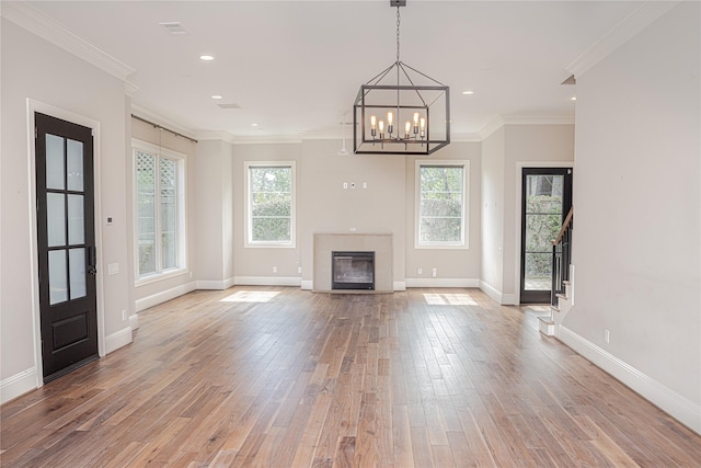 1530 Cunningham Parc Ln, Houston, TX 77055 - unfurnished living room featuring healthy amount of natural light, light wood-style flooring, ornamental molding, a chandelier, and stairs
